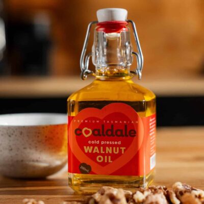 Walnut oil sitting next to walnuts
