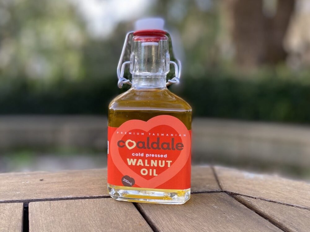 A small clear bottle containing a deep yellow oil, with a red label.