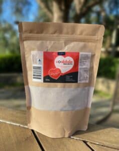 A brown bag of walnut flour with red label sitting on a table.